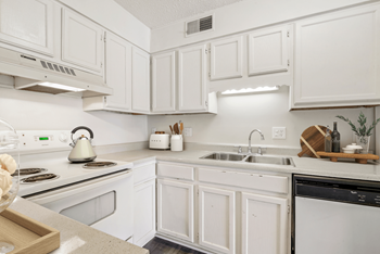 A kitchen with white cabinets and white appliances